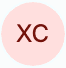 Dark red letters XC displayed in the center of a pale pink circular background.